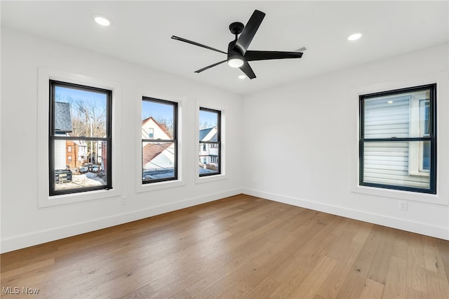 empty room with recessed lighting, wood finished floors, and baseboards