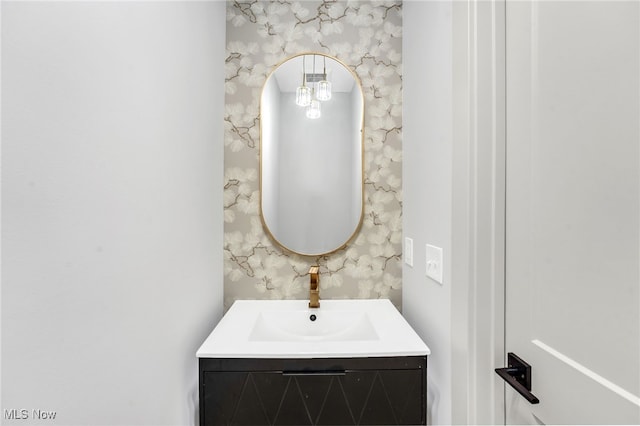 bathroom with vanity and wallpapered walls