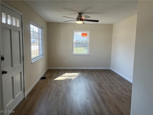 unfurnished room with plenty of natural light, visible vents, and a textured ceiling