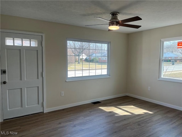 foyer with baseboards, a textured ceiling, wood finished floors, and a ceiling fan