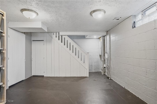 below grade area with stairs, electric panel, and a textured ceiling