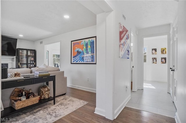 living room featuring recessed lighting, visible vents, wood finished floors, and a fireplace