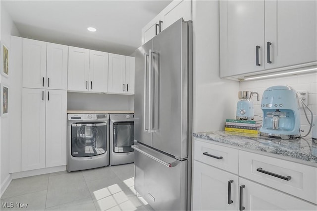 laundry room featuring light tile patterned floors, recessed lighting, laundry area, and washer and clothes dryer