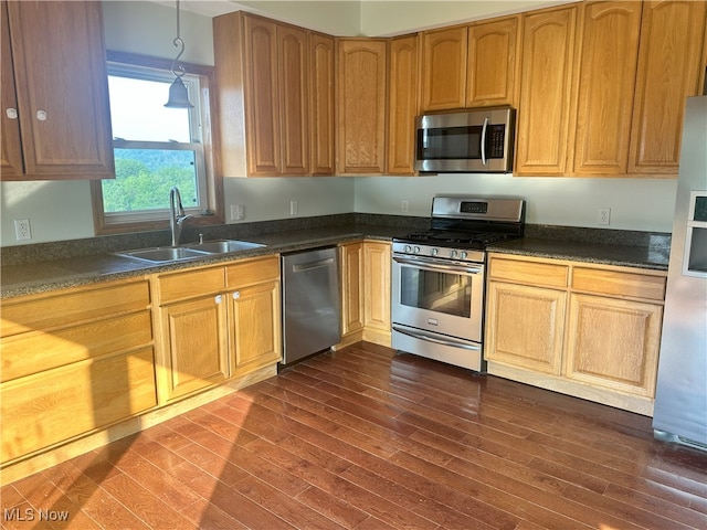 17583 Davis Ridge Rd, Caldwell, OH 43724 - kitchen featuring appliances with stainless steel finishes, a sink, dark wood finished floors, dark countertops, and decorative light fixtures