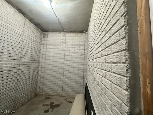 17583 Davis Ridge Rd, Caldwell, OH 43724 - full bath featuring concrete flooring, brick wall, and a shower