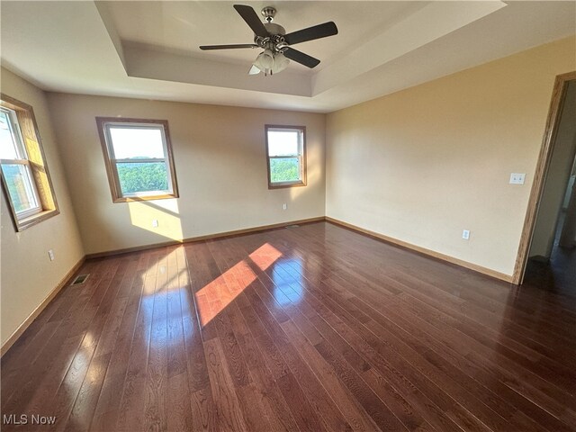 17583 Davis Ridge Rd, Caldwell, OH 43724 - empty room featuring a raised ceiling, baseboards, dark wood-style floors, and a ceiling fan