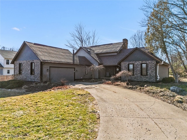 view of front of home with a front lawn, an attached garage, driveway, and a chimney