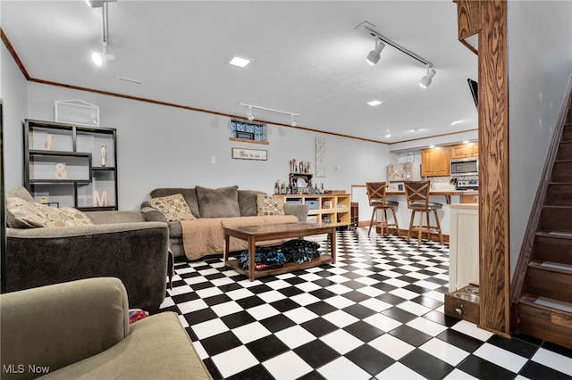 living area featuring tile patterned floors, stairway, rail lighting, and crown molding