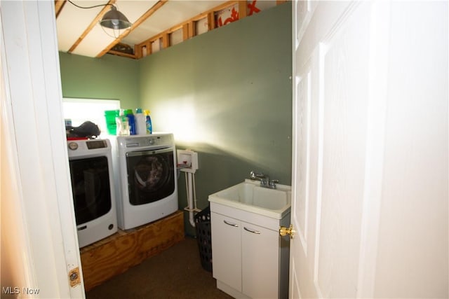 washroom featuring laundry area, washing machine and dryer, and a sink