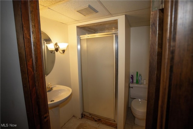 bathroom with visible vents, a drop ceiling, a shower stall, tile patterned floors, and toilet