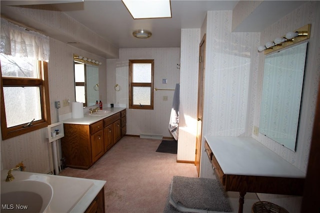 full bathroom featuring baseboards, baseboard heating, vanity, and wallpapered walls