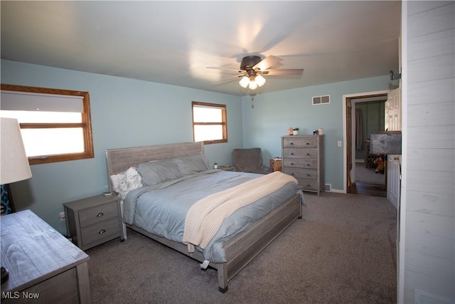 carpeted bedroom with visible vents, baseboards, and a ceiling fan