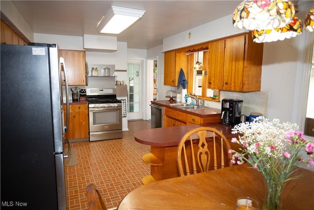 kitchen with a sink, appliances with stainless steel finishes, and brown cabinetry