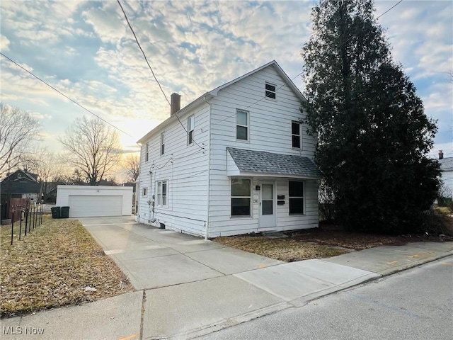 view of front of home featuring a shingled roof, fence, a chimney, a garage, and an outbuilding