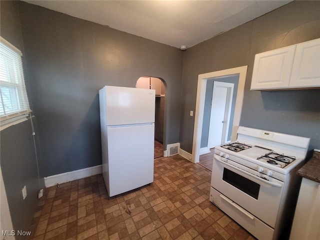 kitchen with white cabinetry, white appliances, baseboards, and visible vents