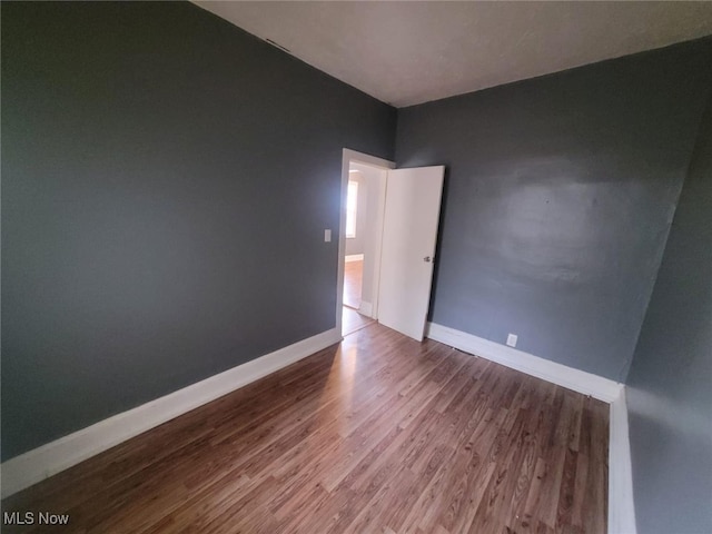 empty room with wood finished floors and baseboards