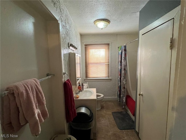 full bathroom featuring vanity, shower / bath combo, a textured ceiling, toilet, and a textured wall