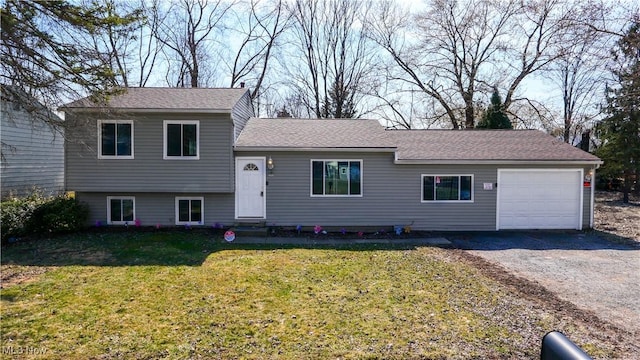 tri-level home with a front lawn, a garage, driveway, and roof with shingles