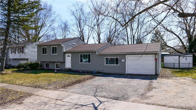 tri-level home with a garage, a front yard, and driveway