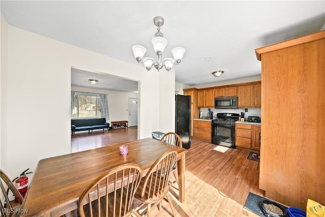 dining space featuring a notable chandelier and light wood-type flooring