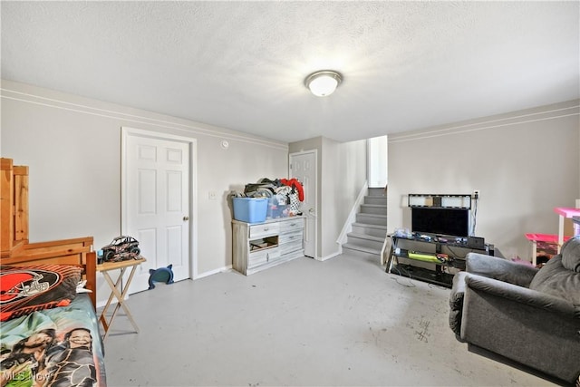 interior space featuring stairs, finished concrete flooring, and a textured ceiling