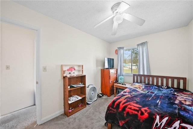 carpeted bedroom featuring baseboards, a textured ceiling, and ceiling fan