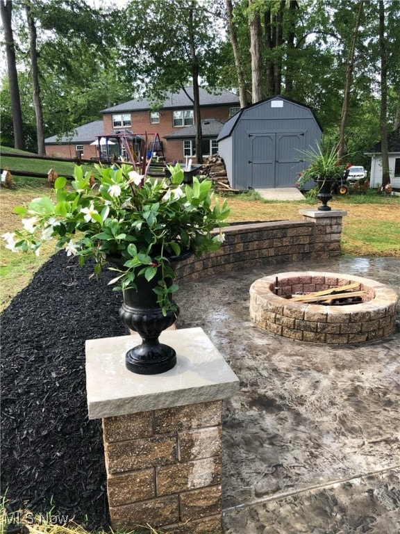 view of yard with a wooden deck, an outbuilding, a storage shed, and a fire pit