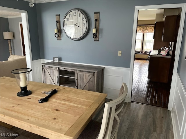 dining space featuring hardwood / wood-style flooring and a wainscoted wall