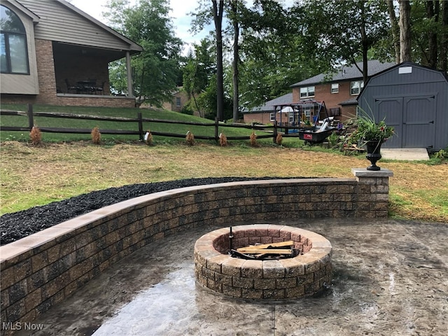 view of patio / terrace with a storage shed, an outdoor structure, and an outdoor fire pit