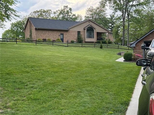 view of front of home featuring brick siding, a front yard, and fence