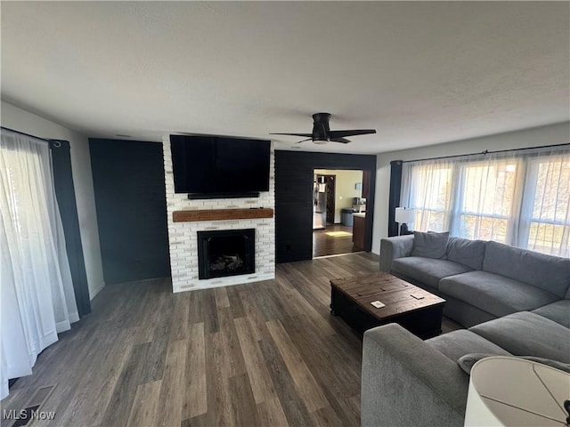 living room with wood finished floors, a fireplace, and ceiling fan