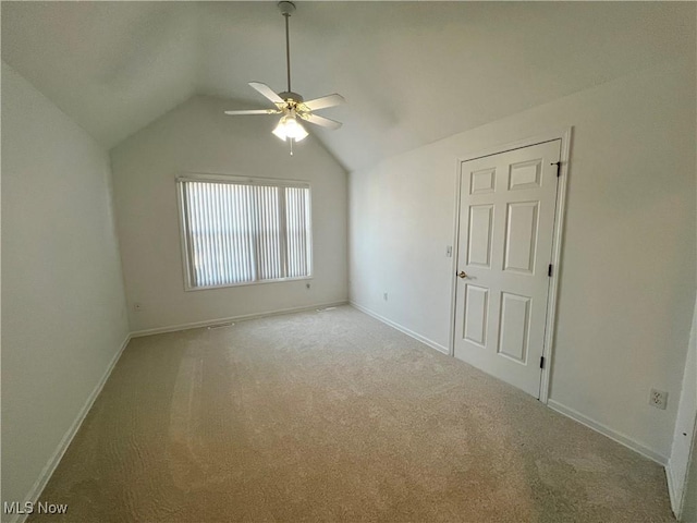 unfurnished bedroom featuring baseboards, carpet, ceiling fan, and vaulted ceiling