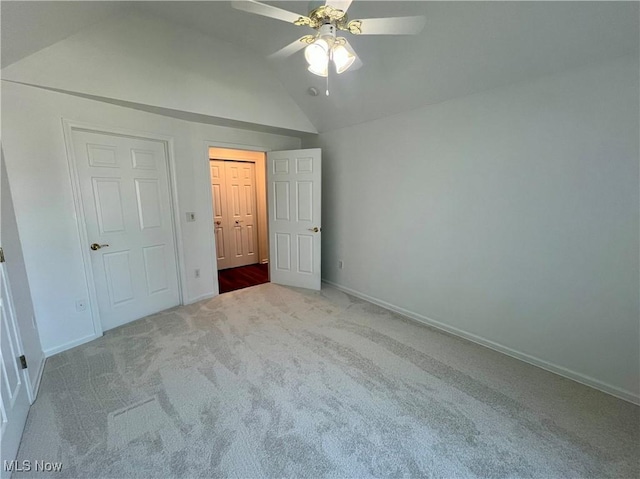 unfurnished bedroom with a ceiling fan, lofted ceiling, carpet, and baseboards