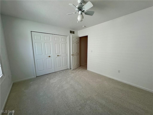 unfurnished bedroom with visible vents, baseboards, a closet, and carpet flooring