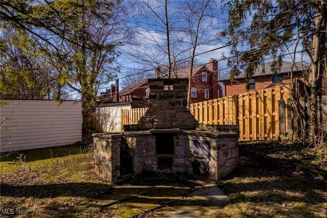 exterior space featuring a fireplace and fence