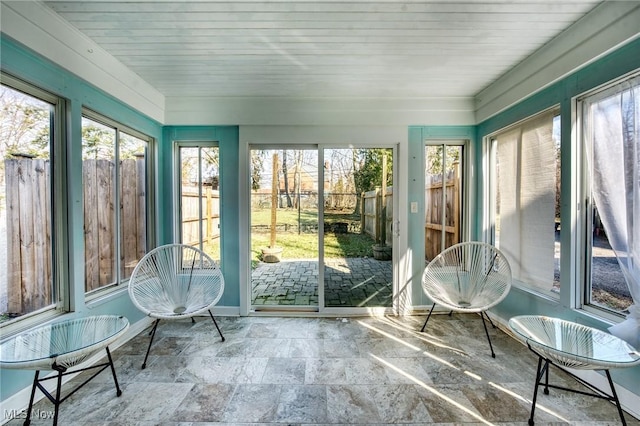 sunroom with a healthy amount of sunlight and wooden ceiling