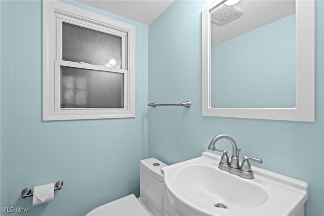 bathroom with a sink, visible vents, and toilet