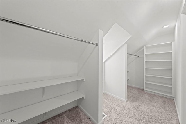 spacious closet with carpet and vaulted ceiling