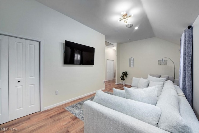 living room featuring visible vents, baseboards, light wood-style floors, and lofted ceiling