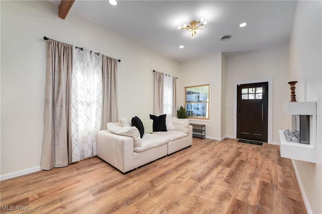 living room featuring recessed lighting, baseboards, visible vents, and light wood-type flooring