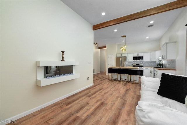 living room with baseboards, visible vents, beam ceiling, light wood-style flooring, and recessed lighting