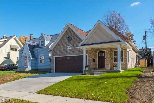 view of front of property with a front yard, a porch, an attached garage, concrete driveway, and brick siding