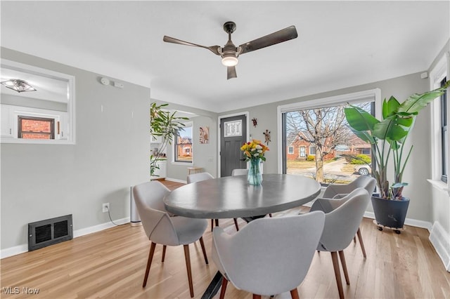 dining space with light wood finished floors, visible vents, baseboards, and a wealth of natural light