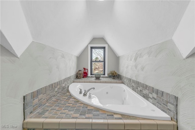 full bath featuring lofted ceiling and a jetted tub