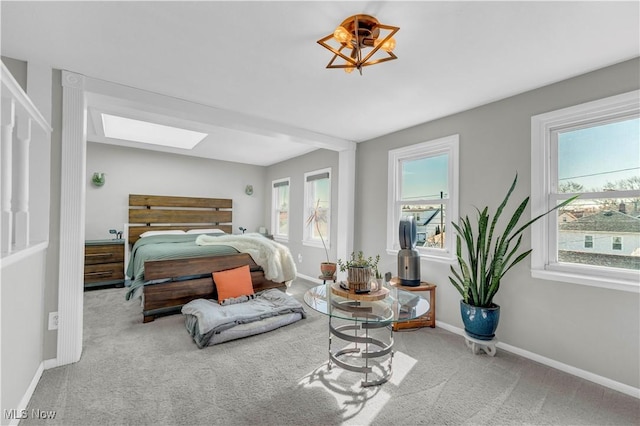 bedroom with a skylight, multiple windows, baseboards, and carpet floors