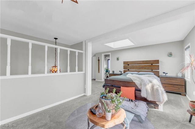 bedroom featuring carpet flooring, a skylight, and baseboards