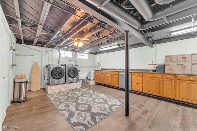 below grade area with separate washer and dryer and light wood-style floors