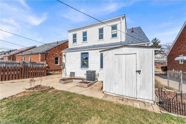 back of house with fence, a shed, cooling unit, a yard, and an outdoor structure