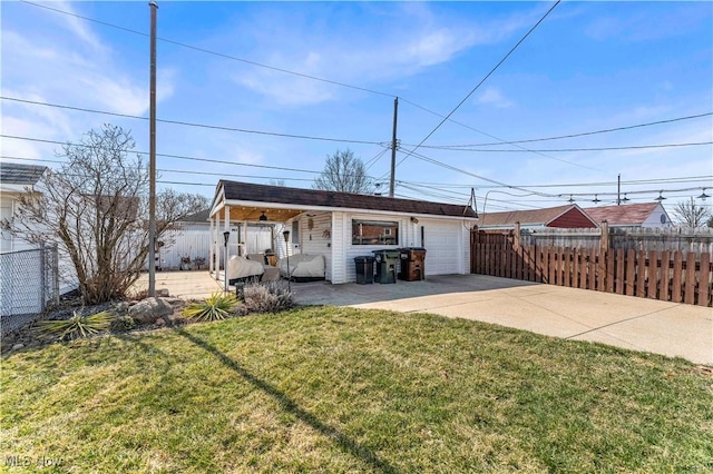 exterior space with an outbuilding, a yard, fence, and driveway