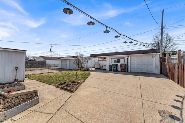 detached garage with a vegetable garden and fence